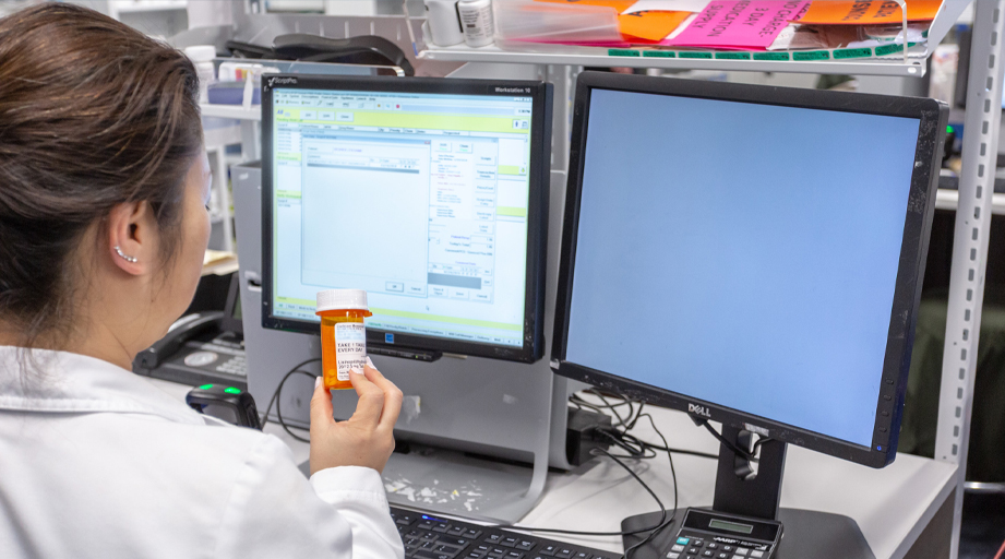 a female pharmacist reviewing medication at a workstation